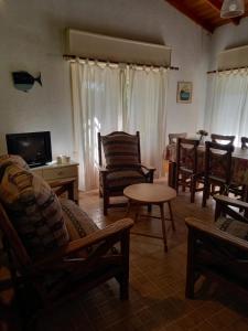 a living room with chairs and a table and a tv at Nuestro Lugar in Villa Gesell
