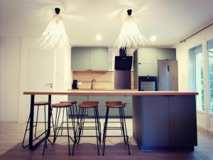 a kitchen with a large island with stools at KiWi in Canet-en-Roussillon