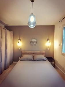 a bedroom with a large white bed with two pillows at KiWi in Canet-en-Roussillon