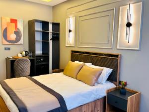 a bedroom with a bed with white sheets and yellow pillows at Skymoon Istanbul Airport Hotel in Arnavutköy