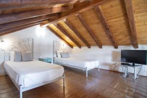 1 Schlafzimmer mit 2 Betten und einem Flachbild-TV in der Unterkunft Villa Theodora View Apartments Thalia in Agios Georgios Pagon