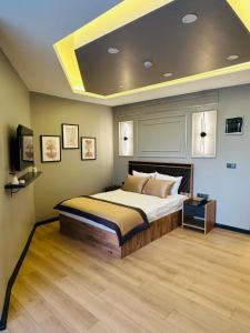 a bedroom with a large bed with a ceiling at Skymoon Istanbul Airport Hotel in Arnavutköy