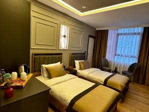 a hotel room with two beds and a window at Skymoon Istanbul Airport Hotel in Arnavutköy