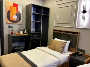 a small bedroom with a bed and a desk at Skymoon Istanbul Airport Hotel in Arnavutköy