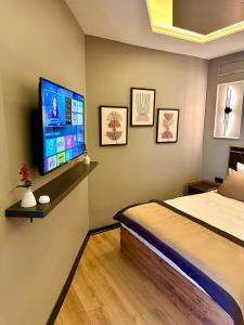 a bedroom with a bed and a flat screen tv at Skymoon Istanbul Airport Hotel in Arnavutköy