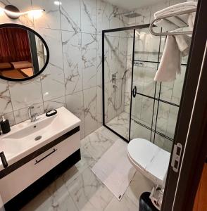 La salle de bains est pourvue d'une douche, d'un lavabo et de toilettes. dans l'établissement Skymoon Airport Hotel, à Arnavutköy