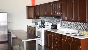 a kitchen with wooden cabinets and a white stove top oven at Quinta Sunset, Lago de Coatepeque in El Congo