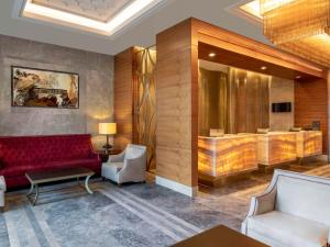 Mövenpick Hotel & Thermal Spa Bursa في بورصة: لوبى به أريكة حمراء وغرفة انتظار