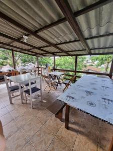 eine Terrasse mit Tischen und Stühlen auf dem Dach in der Unterkunft Pousada Happy in São Francisco do Sul