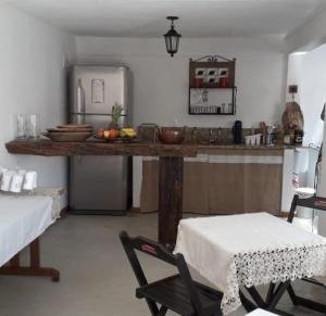 a kitchen with a counter and a table and chairs at Pousada Vila Sol Maior in Guarapari