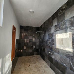 a room with a shower with a tiled wall at Amplia Habitación Privada Centro in Mérida