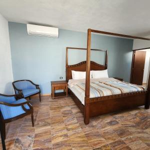 een slaapkamer met een bed en een stoel bij Amplia Habitación Privada Centro in Mérida