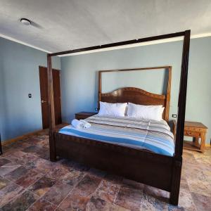 a bed with a wooden frame in a bedroom at Amplia Habitación Privada Centro in Mérida