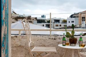 a table and a chair on a balcony with bottles and cactus at Close in Tel Aviv