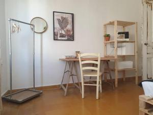 a room with a table and a desk with a lamp at Close in Tel Aviv