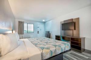 a hotel room with a bed and a television at Motel 6 Texarkana, TX in Texarkana
