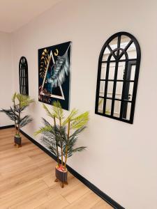 a room with two palm trees and a picture on the wall at Skymoon Istanbul Airport Hotel in Arnavutköy