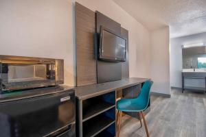 a room with a desk with a television and a chair at Motel 6 Texarkana, TX in Texarkana