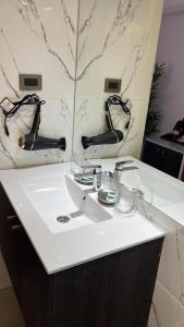 y baño con lavabo blanco y espejo. en Hotel Gran Muso, en Los Ángeles