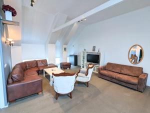 a living room with brown leather furniture and a table at Central Apartments in Vestmannaeyjar
