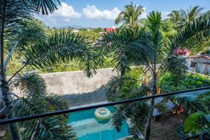 a balcony with palm trees and a swimming pool at Casa Monika Vista Suit in Puerto Escondido