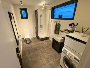 a bathroom with a shower and a sink and a toilet at Central Apartments in Vestmannaeyjar +41 photos