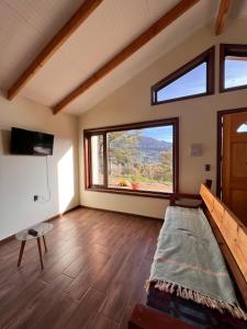 een grote kamer met een groot raam en een bed bij Cabañas Altos del Sollipulli in Rumiñano