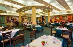 a dining room on a cruise ship with tables and chairs at Mirage Apartments & Aqua Park in Hurghada