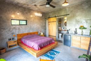 a bedroom with a bed and a kitchen at Casa Monika Vista Suit in Puerto Escondido