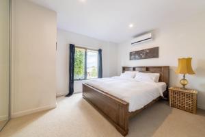 Un dormitorio con una cama grande y una ventana en 3BR Point Cook Holiday Sanctuary, en Point Cook