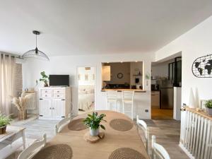 a kitchen and living room with a table and chairs at L’appart in Lisieux