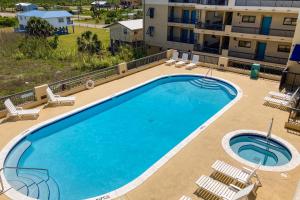 a large swimming pool with chairs and a building at Renovar at The Club in Mexico Beach