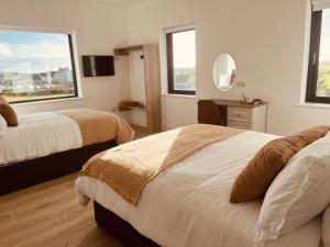 a hotel room with two beds and a mirror at Greene Acres - Room Only in Doolin