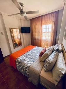 una camera da letto con un grande letto con cuscini sopra di Tu hogar en Tenerife ,Parque Albatros a San Miguel de Abona