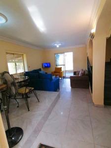 a living room with a blue couch and a table at 5 bedrooms house at Markaz Al Alamein 700 m away from the beach with shared pool enclosed garden and wifi in El Alamein
