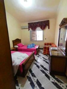 a bedroom with two beds and a table and a window at 5 bedrooms house at Markaz Al Alamein 700 m away from the beach with shared pool enclosed garden and wifi in El Alamein