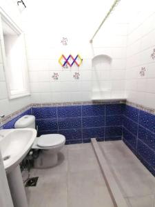 a blue and white bathroom with a toilet and a sink at 5 bedrooms house at Markaz Al Alamein 700 m away from the beach with shared pool enclosed garden and wifi in El Alamein