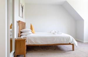 1 dormitorio con 1 cama con sábanas y almohadas blancas en One Mill Lands, en Uig