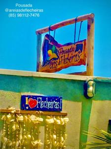 two signs on the side of a building at Pousada Areias de Flecheiras in Flecheiras