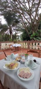 a white table with plates of food on it at Pousada Florada na Serra in Serra do Cipo