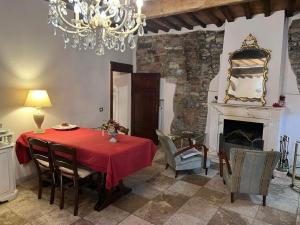 a dining room with a red table and a fireplace at La Piazzetta Toscana B&B in Campiglia Marittima
