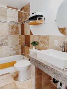 a bathroom with a toilet and a sink and a tub at Honomu Inn in Honomu