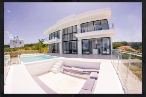 une grande maison blanche avec une piscine dans l'établissement Villa Ocean Blue, à Las Terrenas