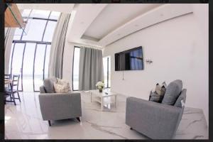 un soggiorno bianco con 2 sedie e una TV di Villa Ocean Blue a Las Terrenas