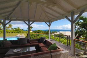 a patio with a couch and a view of the ocean at Yin & Yang in Sainte-Anne