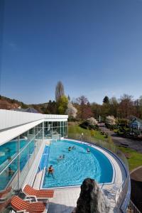 a swimming pool with people in a building at Göbel's Hotel AquaVita in Bad Wildungen