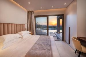 a bedroom with a large white bed and a balcony at Maravilla Luxury Living in Kos