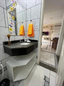 La salle de bains est pourvue d'un lavabo et d'un miroir. dans l'établissement Casa temporada Aracaju, à Aracaju