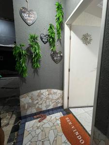 a bathroom with a shower with plants on the wall at Casa temporada Aracaju in Aracaju