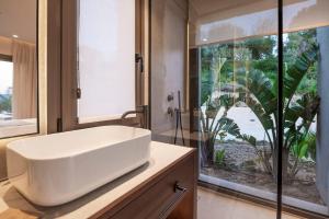 a bathroom with a white sink and a large window at Maravilla Luxury Living in Kos Town